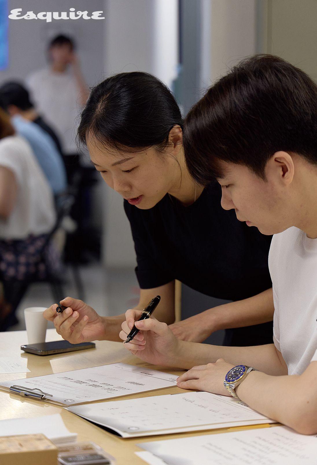 지도 강사의 코칭에 따라 캘리그래피를 배우고 있는 클럽 에스콰이어 멤버.