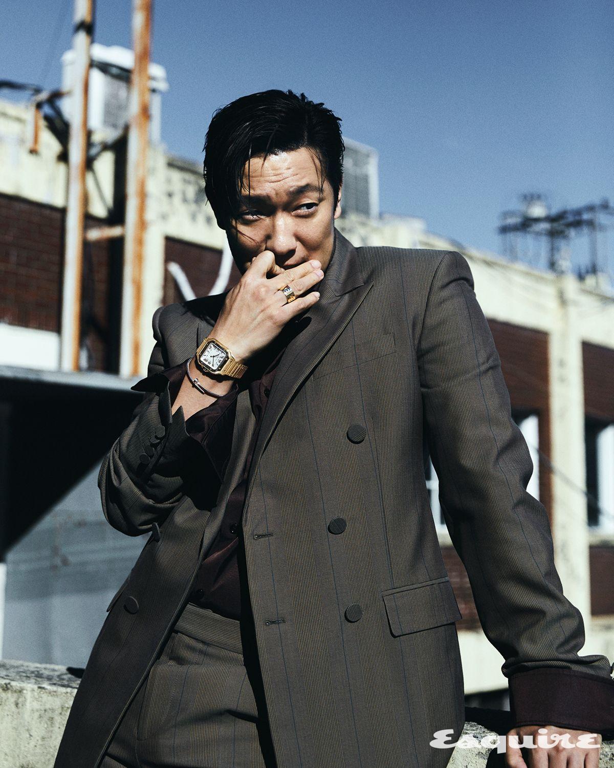 옐로 골드 케이스와 브레이슬릿의 산토스 드 까르띠에 워치, 오른손 약지에 낀 옐로 골드 라지 LOVE 링, 화이트 골드 저스트 앵 끌루 브레이슬릿, 모두 까르띠에. 재킷, 셔츠, 팬츠 모두 버버리.