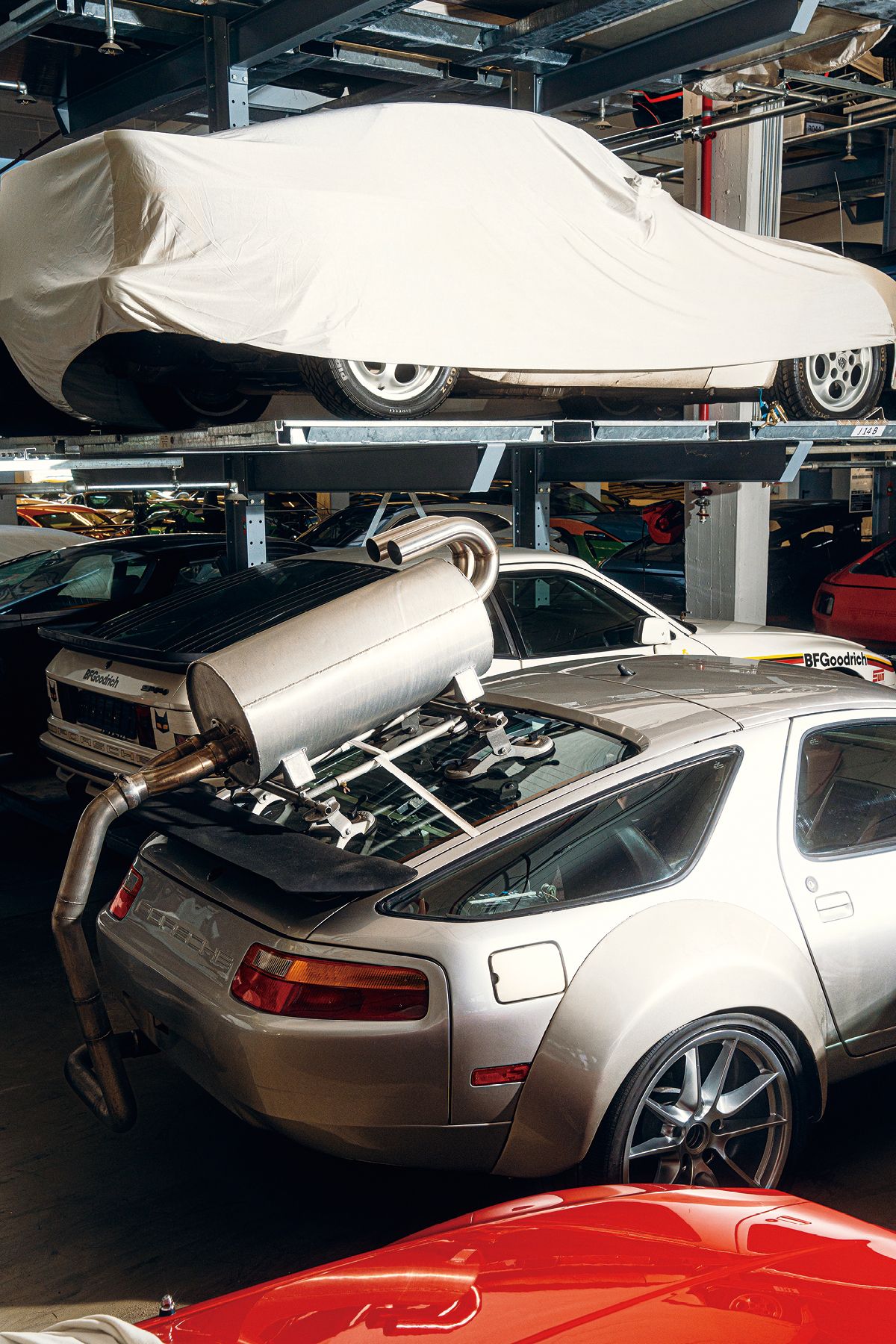 이렇게 덮어씌워 놓은 차들이 무엇인지는 큐레이터만 안다. 리어 해치 뒤에 커다란 머플러가 달린 928은 가려놓아도 알아볼 수 있다. 운행 소음 특성 연구에 사용된 차량이다.