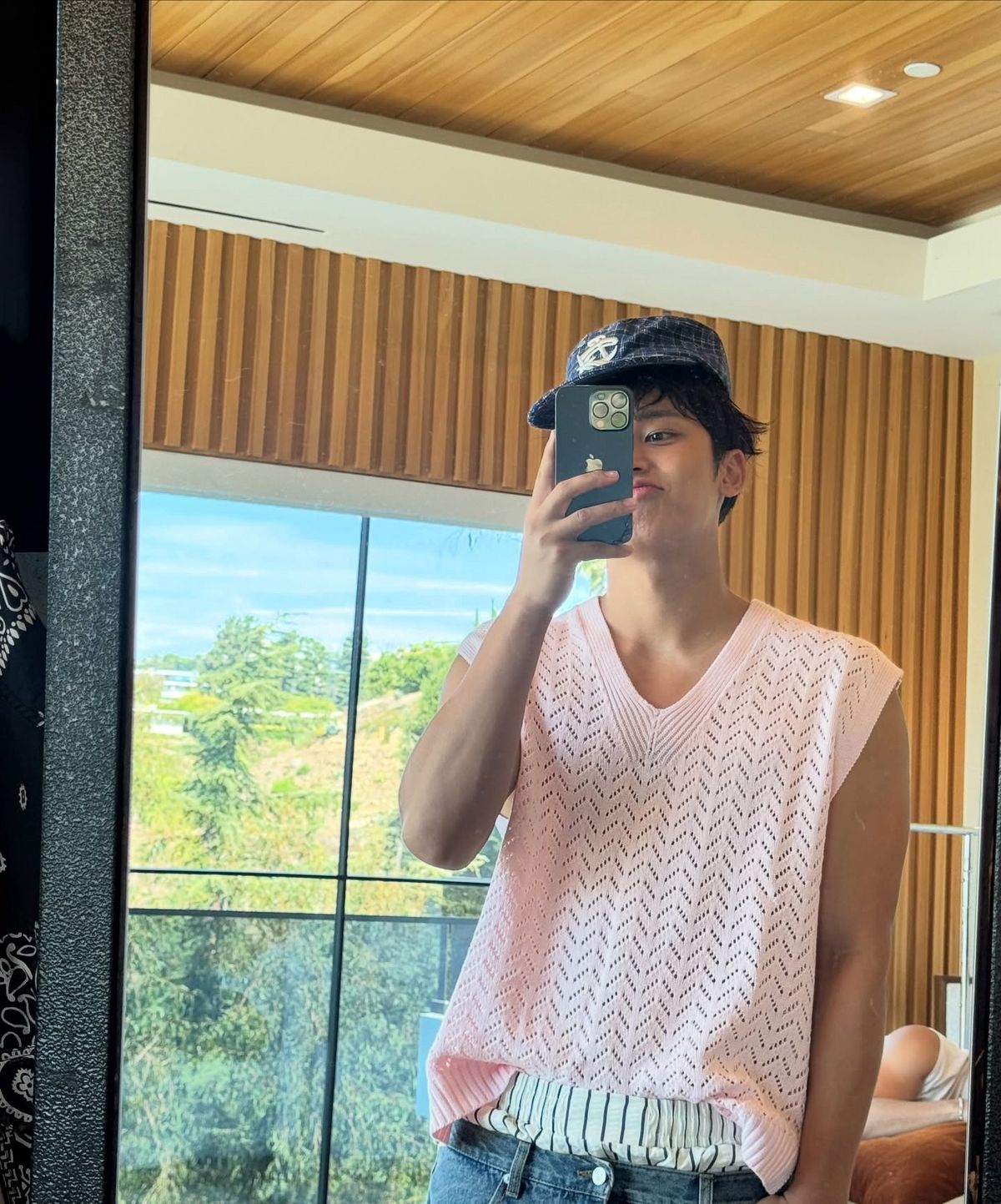 핑크 베스트와 데님 팬츠로 장난스러운 룩을 선보인 민규 / 출처: 인스타그램 @min9yu_k