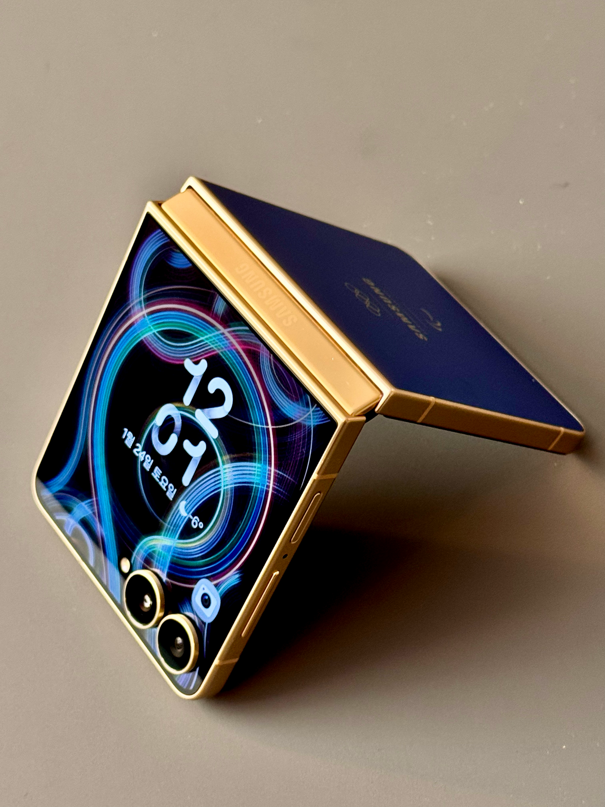 갤럭시 Z 플립7 2026 밀라노 코르티나 올림픽 에디션. 딥 블루 컬러의 후면, 골드 컬러 프레임, 빙판을 형상화한 전용 테마의 조화가 돋보인다.