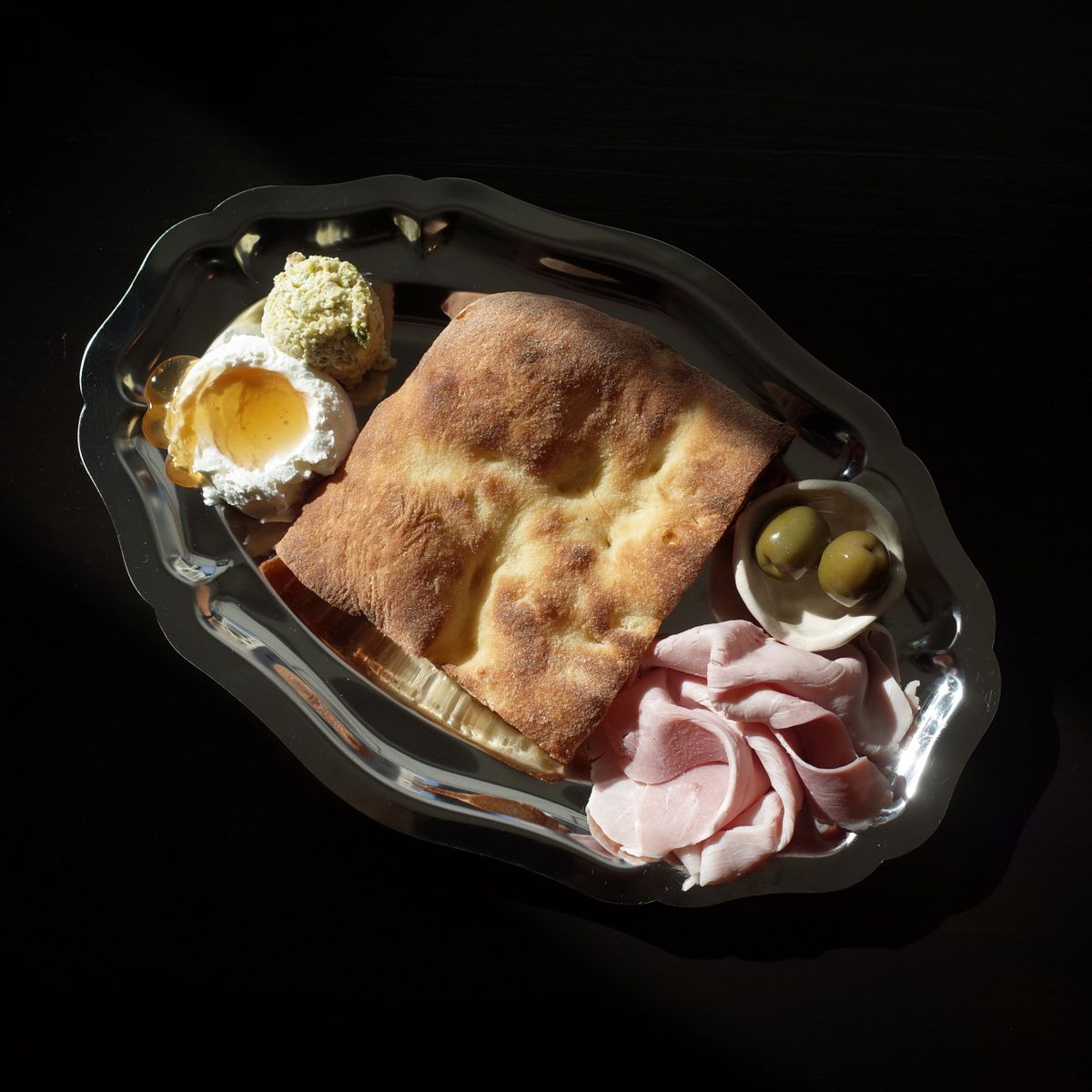 토스트한 스키아차타 빵과 2종의 소스, 잠봉, 그린 올리브로 구성된 ‘TTC 모닝 플레이트’는 담백한 빵 맛을 한껏 즐길 수 있는 메뉴다. / 이미지 출처: 토스티드 클럽 네이버지도 업체 제공 이미지