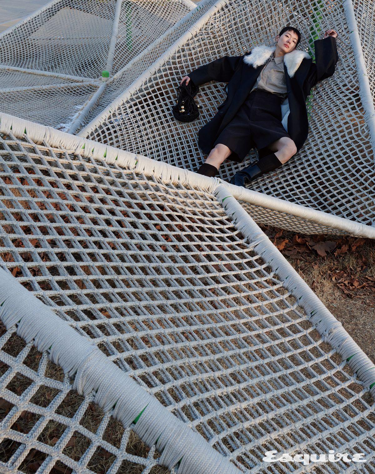 트렌치코트, 셔츠, 쇼츠, 삭스, 부츠, 네트 백 모두 보테가 베네타.