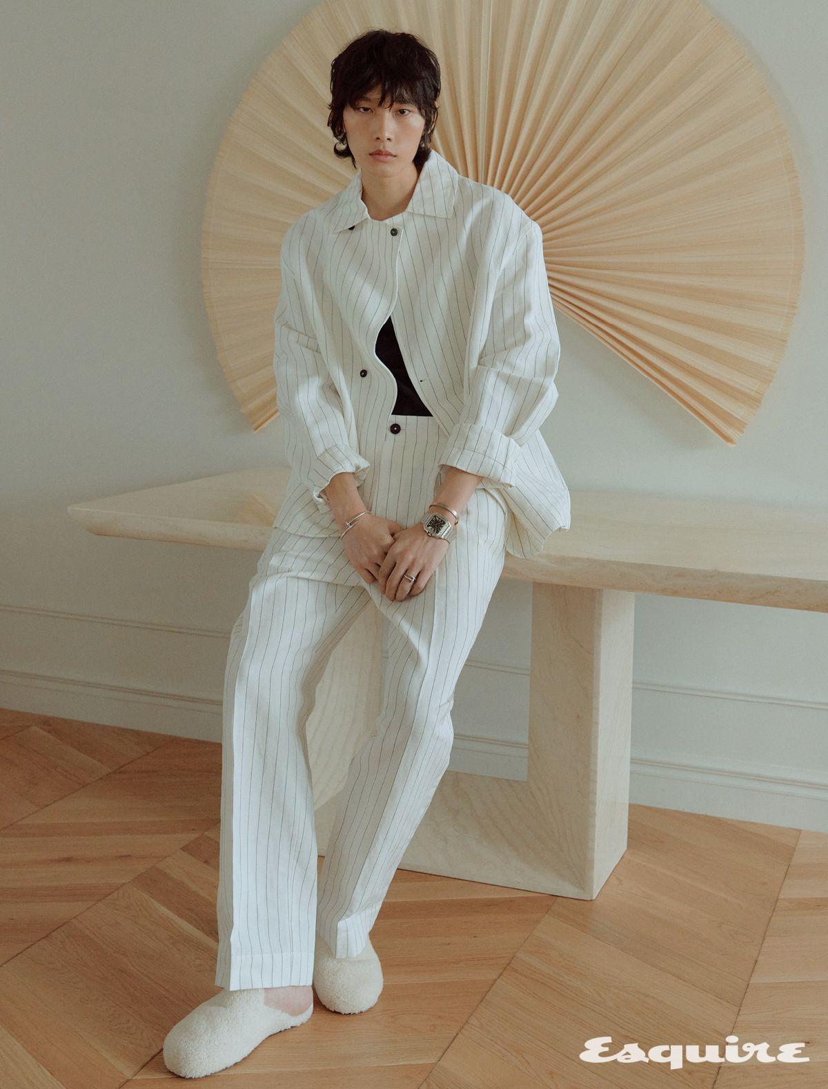 오른손에 착용한 화이트 골드 저스트 앵 끌루 브레이슬릿, 왼손에 착용한 화이트 골드 브러시드 피니싱 LOVE 브레이슬릿, 스틸 케이스에 블랙 다이얼을 적용한 산토스 드 까르띠에 라지 워치, 약지에 낀 화이트 골드 저스트 앵 끌루 링. 스트라이프 재킷, 팬츠 모두 자크뮈스. 이너 톱 순진. 슬리퍼 테클라.