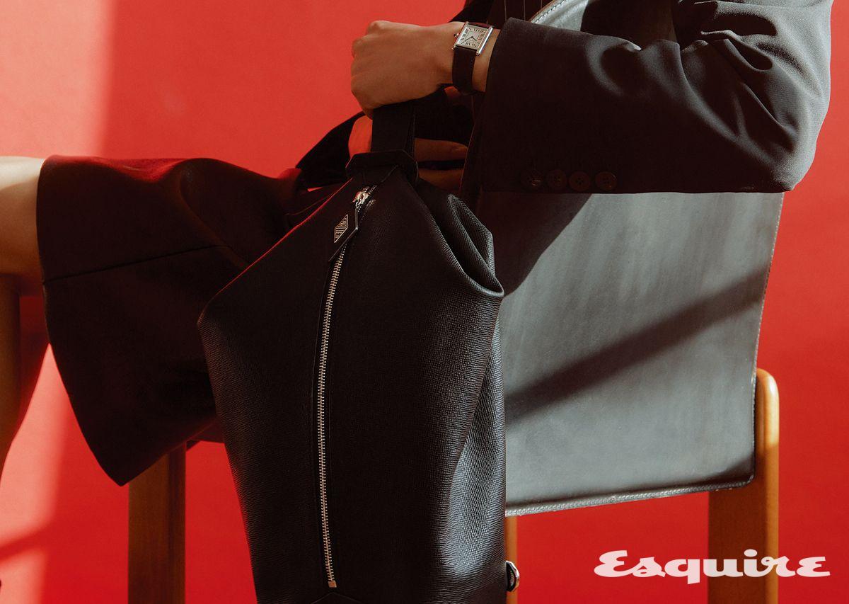 스틸 케이스에 블랙 그레인 레더 스트랩을 매치한 탱크 머스트 라지 워치, 까르띠에 로장쥬 백팩. 재킷 어네스트 W. 베이커 by 10 꼬르소 꼬모 서울. 쇼츠 YCH.