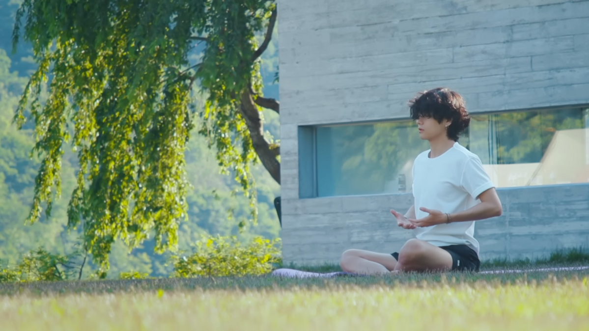 레이크192 잔디에서 명상을 하고 있는 뷔. / 이미지 출처: INTHESOOP_TV