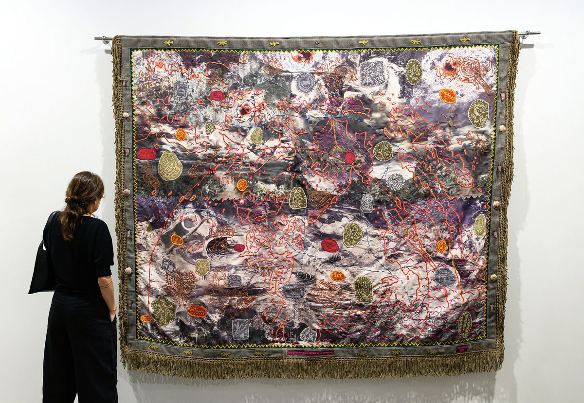 시안 다이릿(Cian Dayrit), 에코스(Echoes) 섹터 전시 전경, 아트 바젤 홍콩 2026. 필리핀의 지형도 위에 텍스트·아카이브 이미지·원주민 신화의 상징들을 중첩시킨 직조 작품. 작가는 이를 '대항 카토그래피(counter-cartography)'라 부른다. © Courtesy of Art Basel 