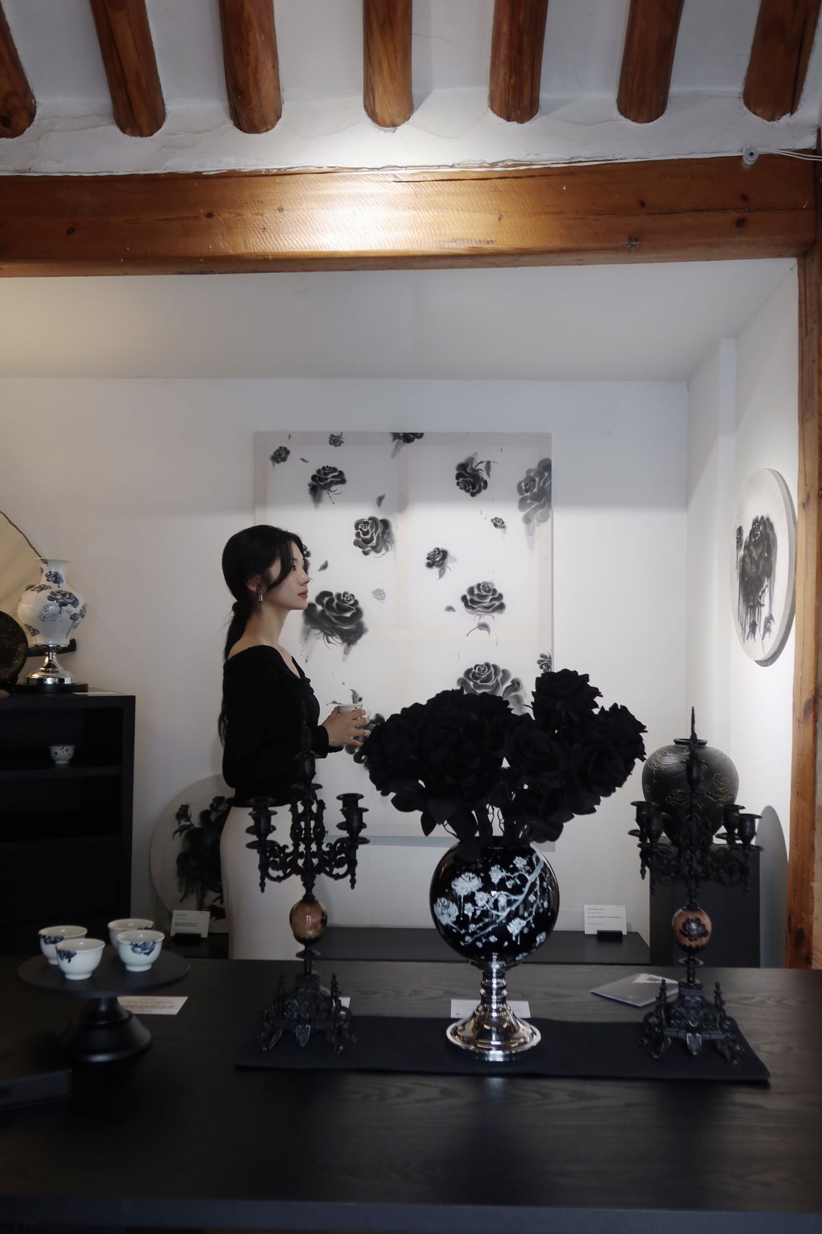 실제 주택의 거실을 전시 공간으로 재해석한 ‘The Rose Lounge’. 대청마루와 원목 가구 위로 부채, 화병, 찻잔, 원화가 어우러지며 장미의 세계로 관람객을 맞이한다. / 이미지 출처: 필자 촬영