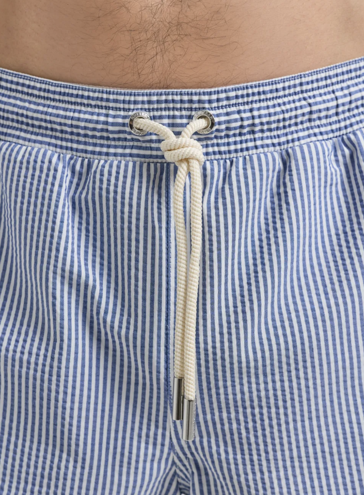 시어서커 소재와 블루 앤 화이트 스트라이프 패턴이 돋보이는 남자 수영복 바지 / 이미지 출처: 파페치