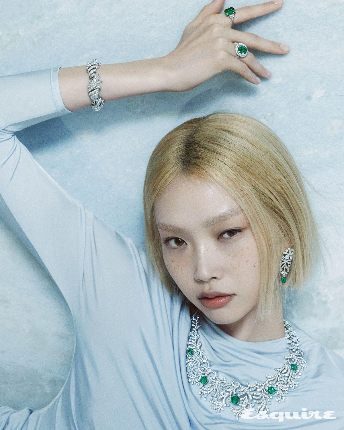 검지에 낀 에메랄드 컷 에메랄드와 다이아몬드로 완성한 하이 주얼리 링, 약지에 낀 플래티넘 소재에 오벌 컷 에메랄드와 다이아몬드를 세팅한 하이 주얼리 링, 입체적인 조형미가 눈길을 끄는 쿠션 컷 다이아몬드를 파베 세팅한 쉘 브레이슬릿, 플래티넘에 쿠션 컷 에메랄드와 다이아몬드를 세팅한 오션 플로라 이어링, 쿠션 컷 에메랄드와 다이아몬드를 세팅한 오션 플로라 네크리스 모두 티파니앤코. 스카이 블루 미니드레스 셀프 포트레이트.