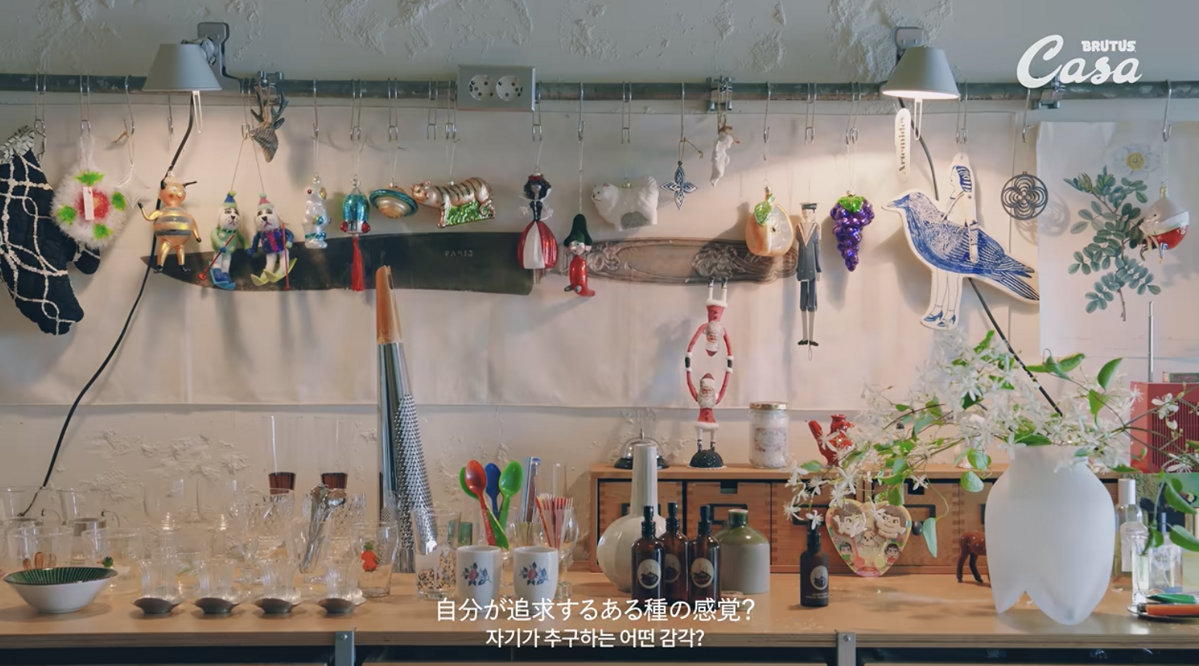 다양한 잔과 수저 등을 올려둔 주방의 서랍장 위에 놓인 백화등. / 이미지 출처: 유튜브 @CasaBRUTUSmag