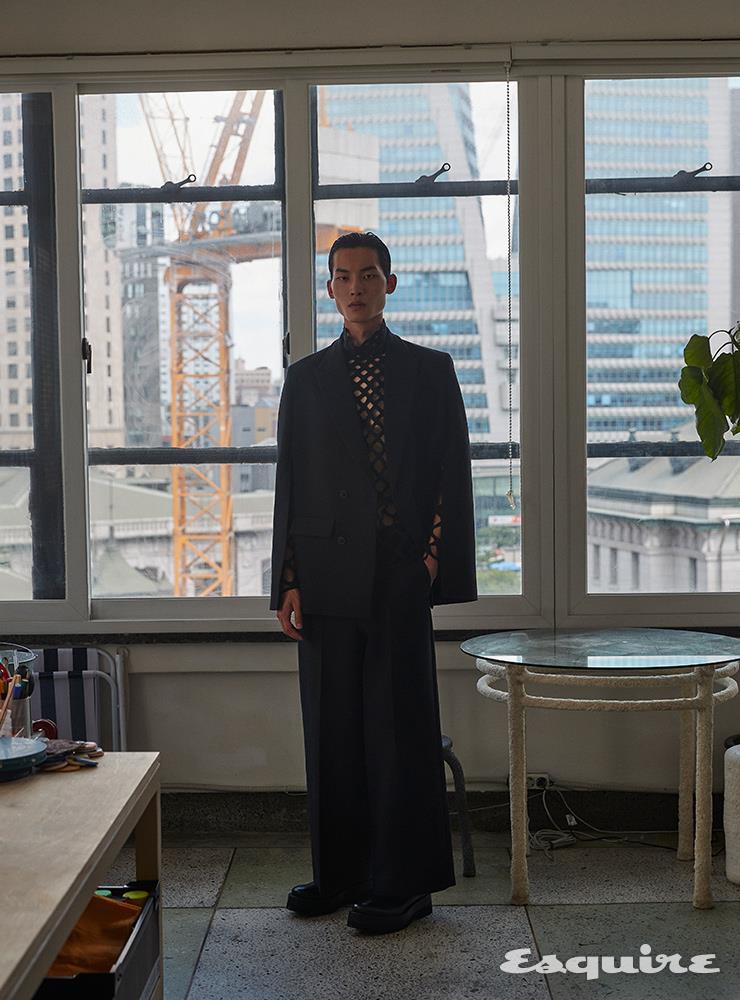 케이프 재킷 310만원, 네트 톱, 와이드 팬츠 모두 가격 미정 발렌티노. 더비 슈즈 123만원 발렌티노 가라바니. 폐종이로 만든 테이블 가격 미정 오유우.