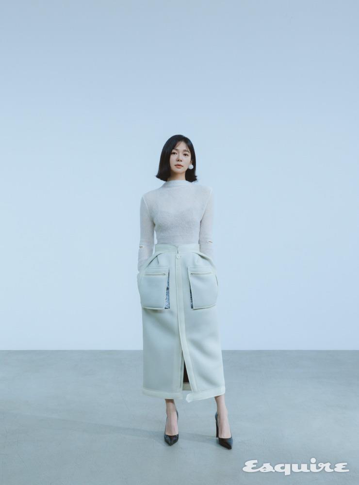 아이보리 니트 르비에르. 화이트 스커트 메종 마르지엘라. 슈즈 지미추. 이어링 시몬로샤.